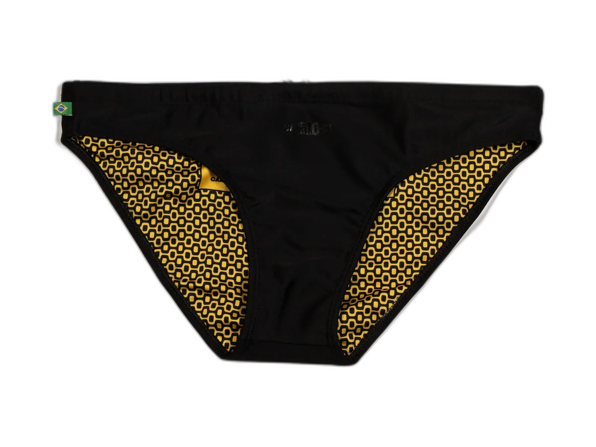 Black CA-RIO-CA bikini-cut sunga with a yellow patterned lining, isolated on a transparent background.