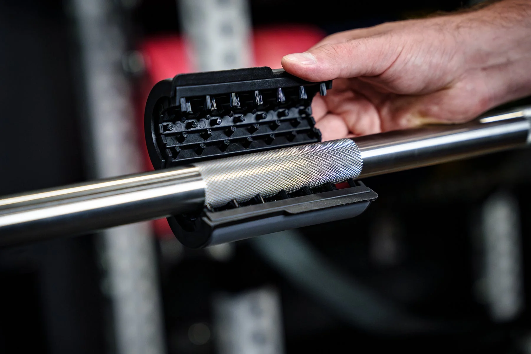 Barbell Rescue Nylon Brush positioned around a knurled barbell in an official in-use photo.